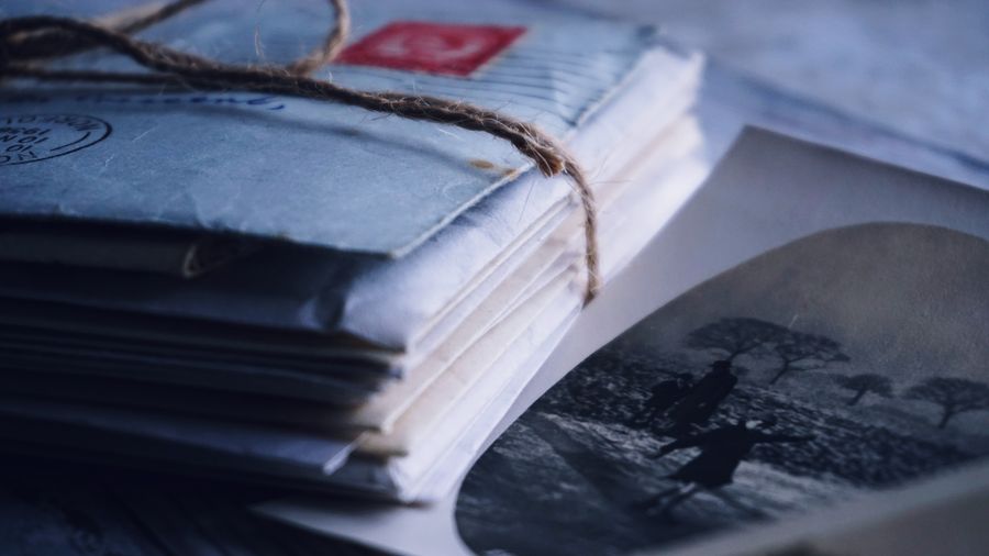 A bundle of old letters tied with twine beside a black-and-white photograph