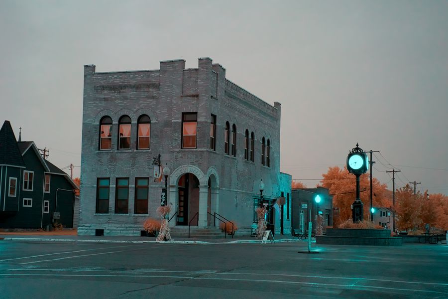 A brick corner building beside a traffic light at dusk