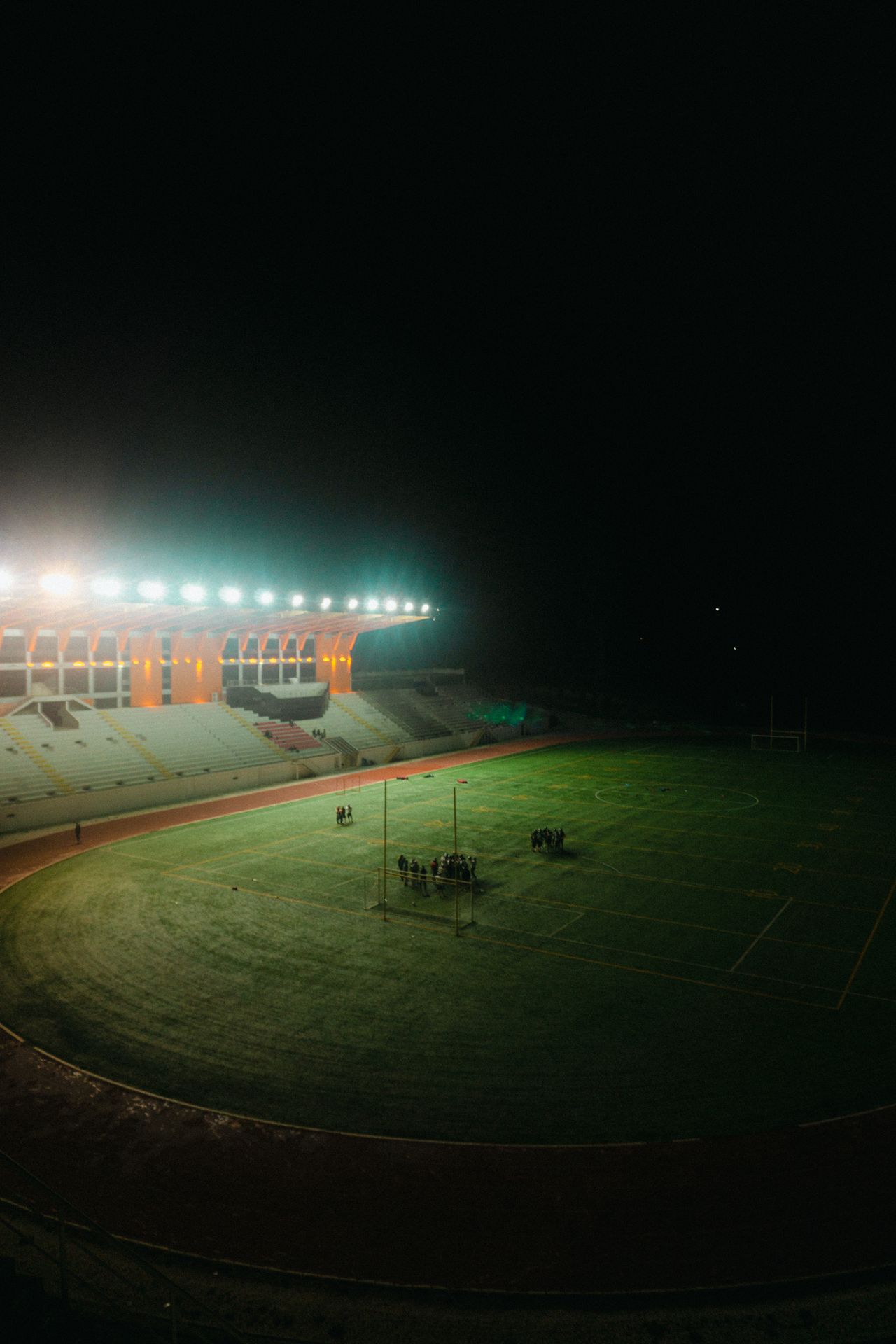 An empty stadium lit under floodlights at night